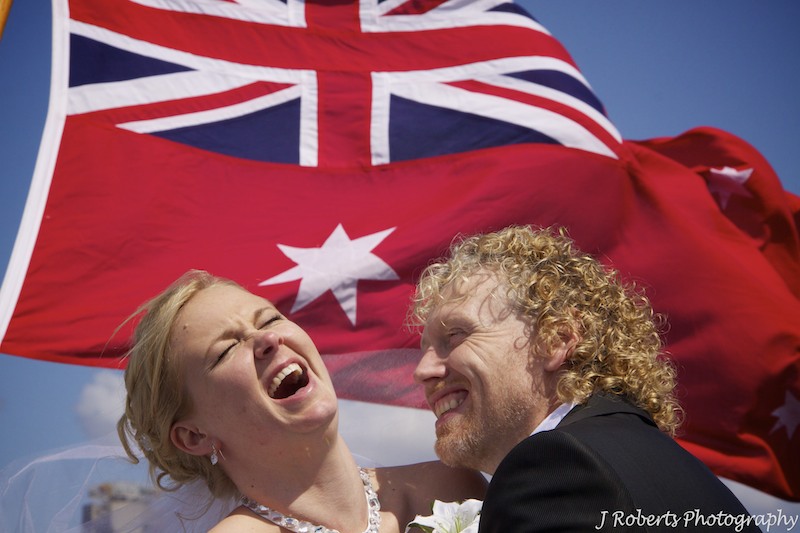 Bride and groom laughing with admirals flag flying - wedding photography